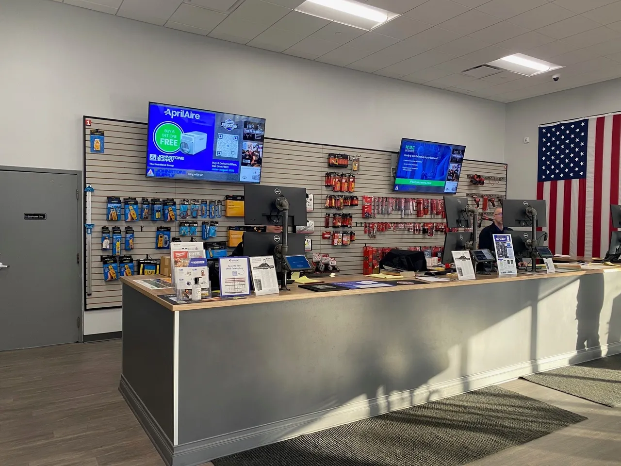 A counter in front of a wall with several tvs on it.